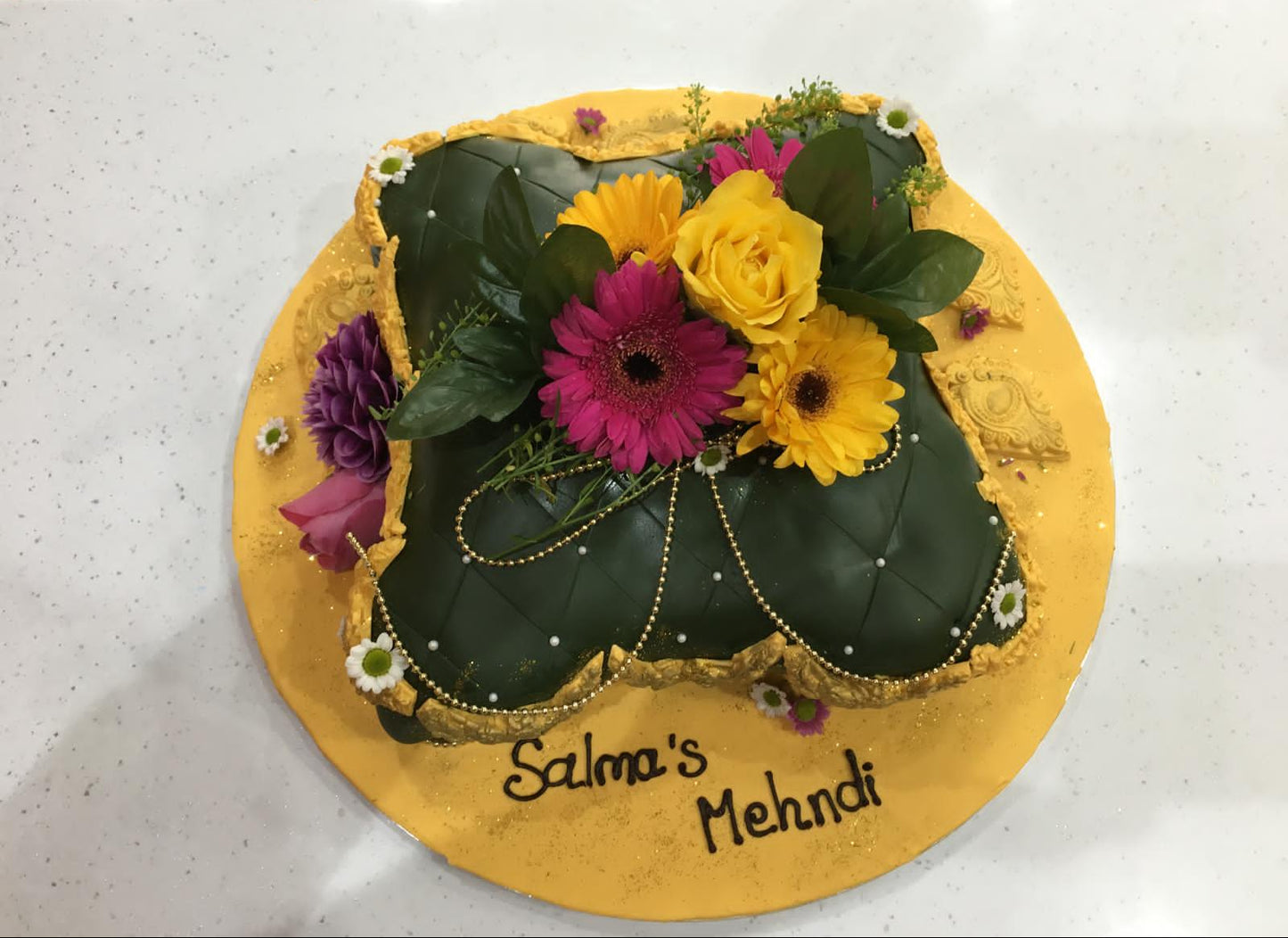 Decorative cake with flowers and text on a white surface