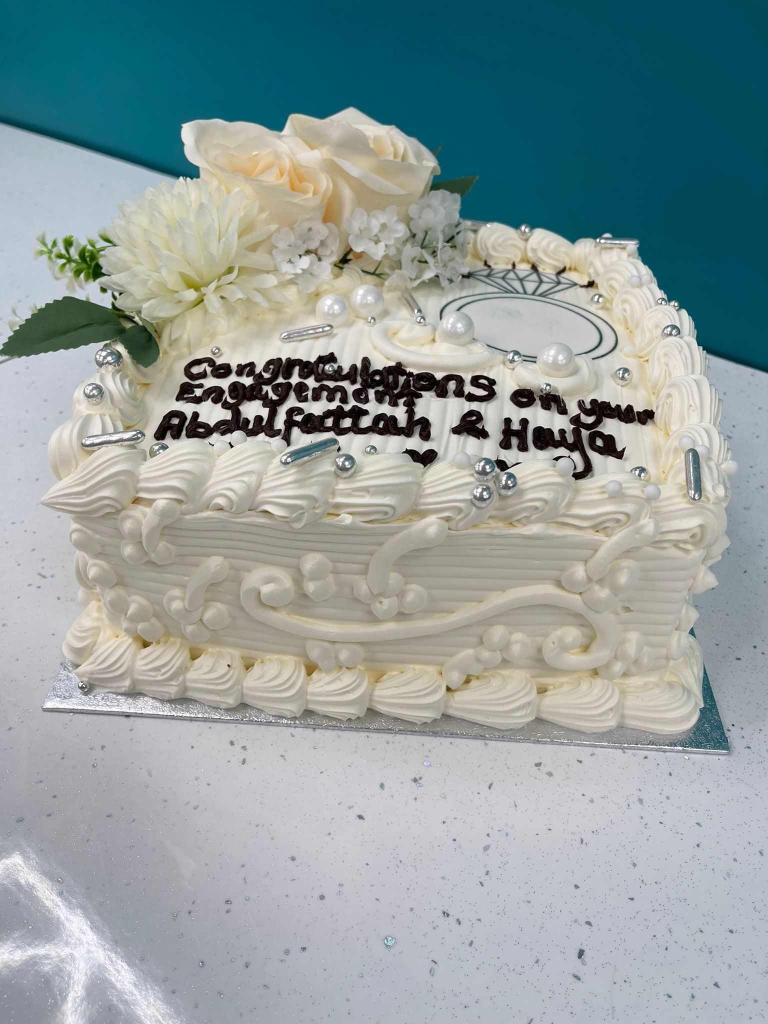 Decorative white cake with flowers and text on a blue background