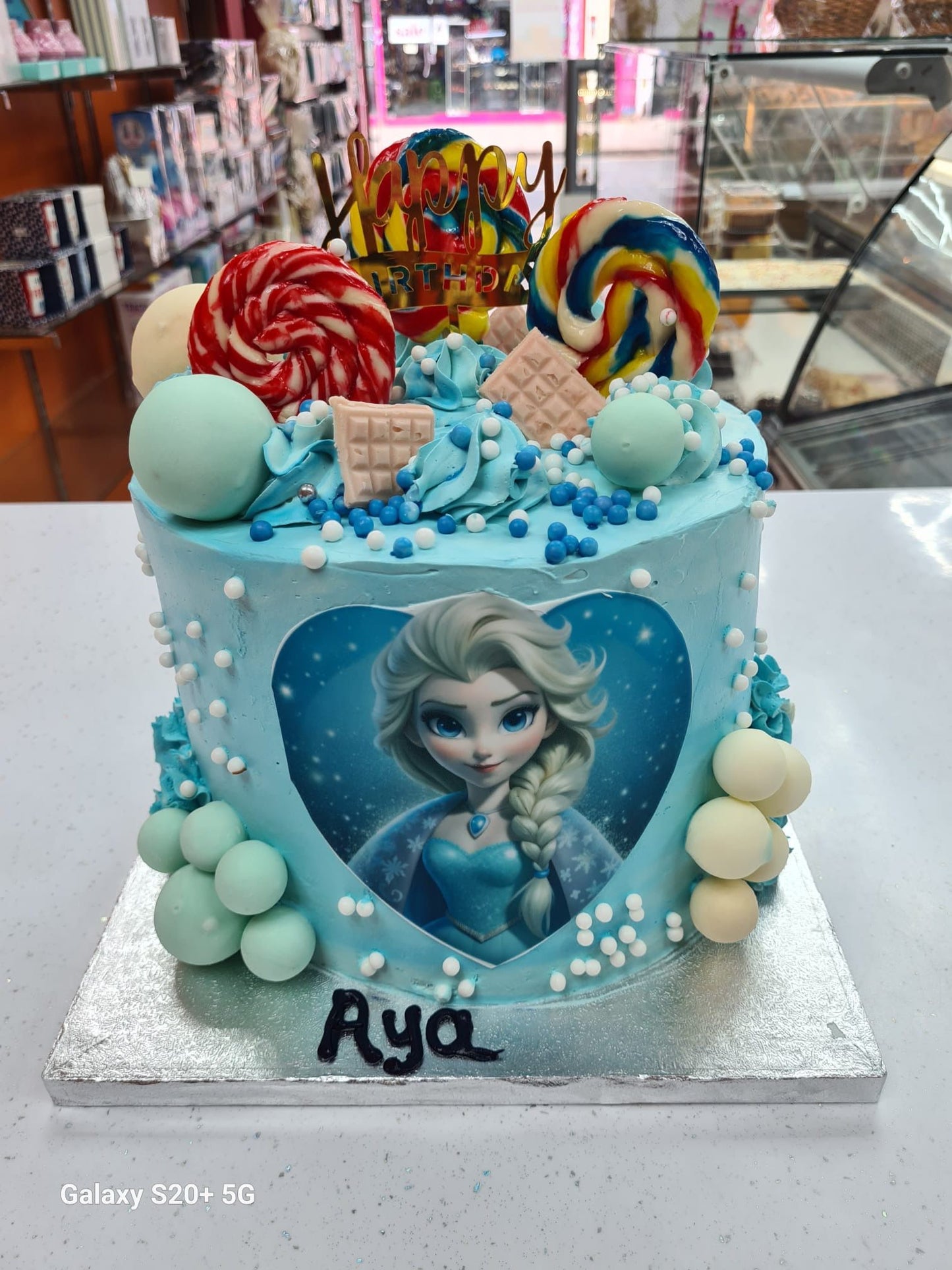 Decorative cake with a character design and colorful candies in a store setting